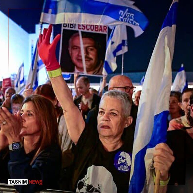A crowd of people wave blue-and-white Israeli flags and hold a poster reading "DIDI ESCOBAR" featuring two faces, with a woman in the foreground raising her red-gloved hand.
