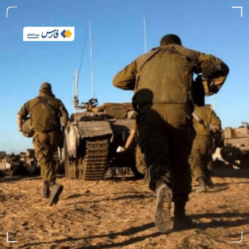 Soldiers in green uniforms run toward a tank in a sandy, open area under a clear blue sky.