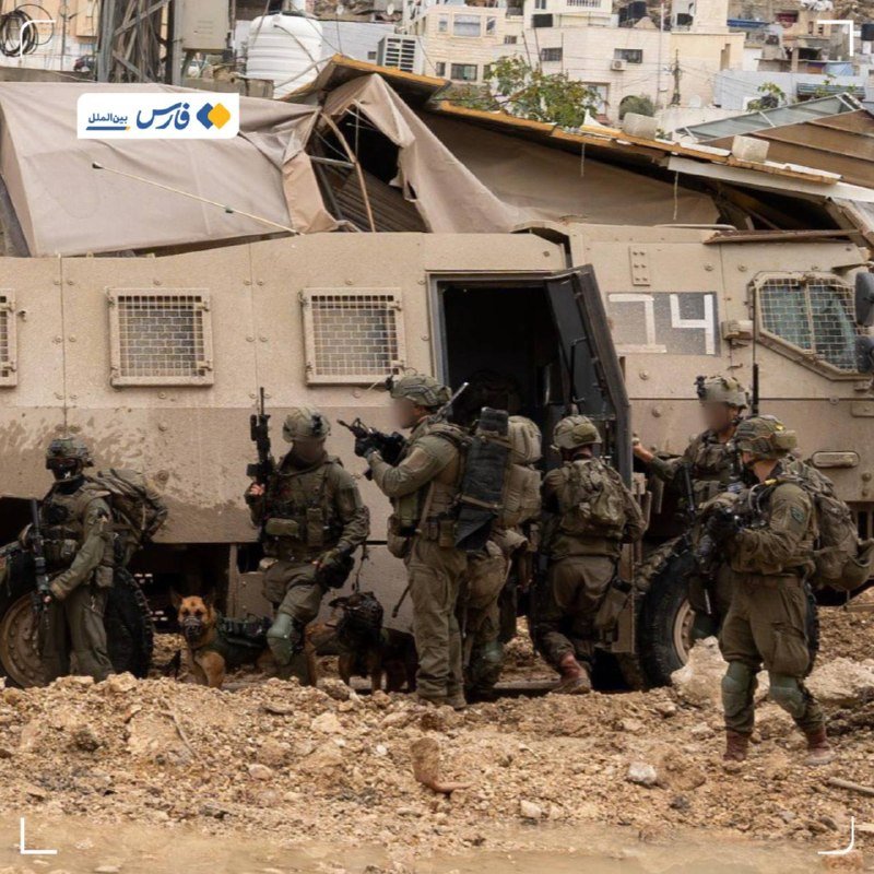 Armored soldiers with rifles and two working dogs exit a tan armored vehicle marked "14" amid rubble, with buildings visible in the background.