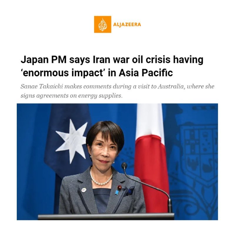 A woman in a gray suit stands at a podium before a microphone, with the Australian and Japanese flags displayed behind her.