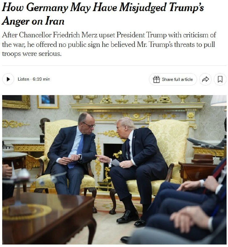 Two men in dark suits sit in ornate yellow chairs in a gilded room, leaning toward each other in conversation.