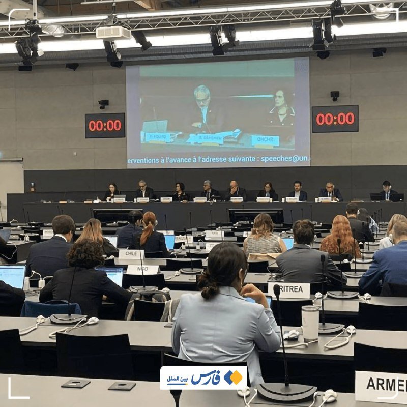 Attendees seated at desks with country nameplates face a panel and a large screen displaying speakers, with digital timers showing 00:00.