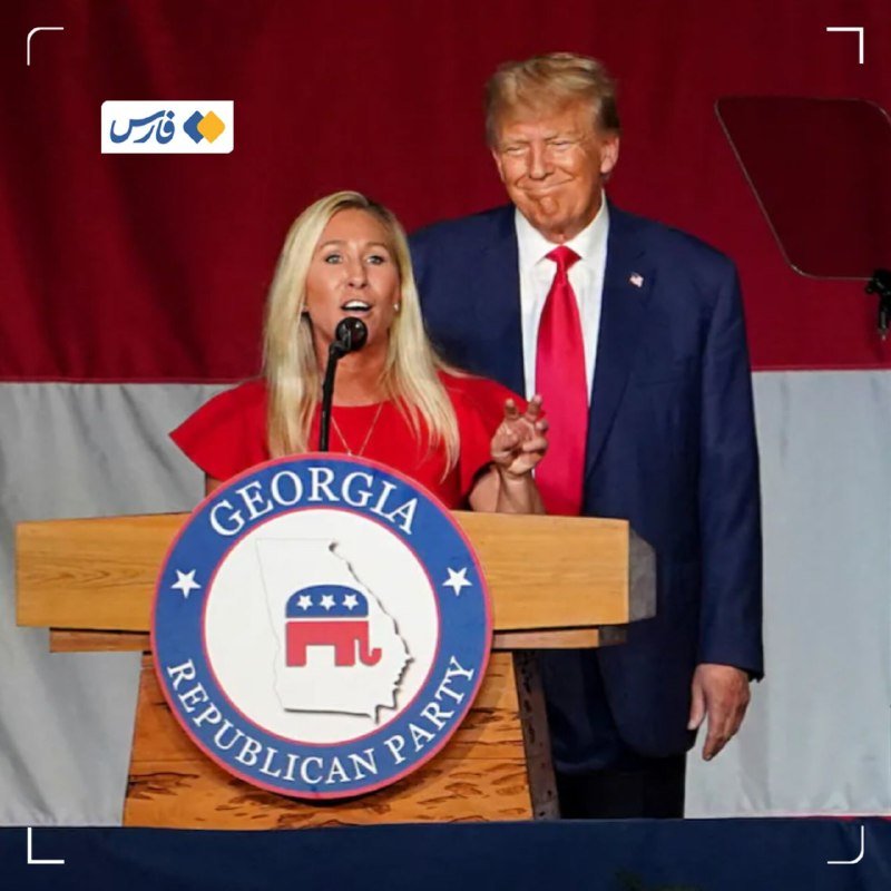 A blonde woman in a red dress speaks at a podium displaying the Georgia Republican Party seal, while a man in a blue suit and red tie stands behind her.