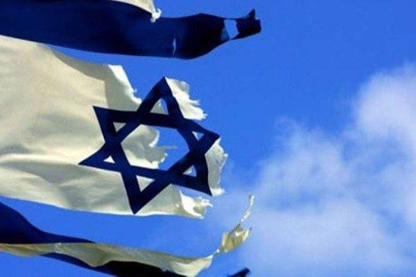 A tattered Israeli flag with a blue Star of David waves against a partly cloudy blue sky.