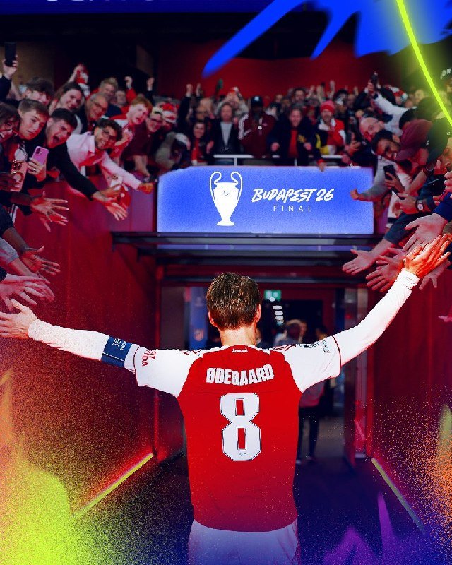 A footballer wearing a red and white jersey with "ØDEGAARD" and the number 8 walks toward cheering fans with arms outstretched beneath a "BUDAPEST 26 FINAL" sign.