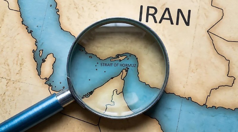 A magnifying glass rests on a map, enlarging the labeled "Strait of Hormuz" near "Iran."