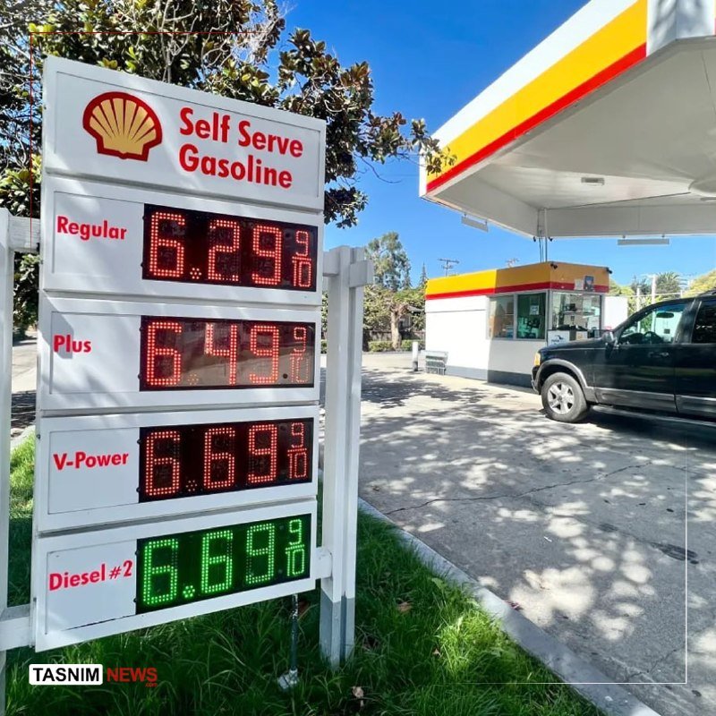 A Shell gas station price sign displays Regular at $6.29, Plus at $6.45, V-Power at $6.69, and Diesel #2 at $6.69, with a black SUV parked nearby under a canopy.