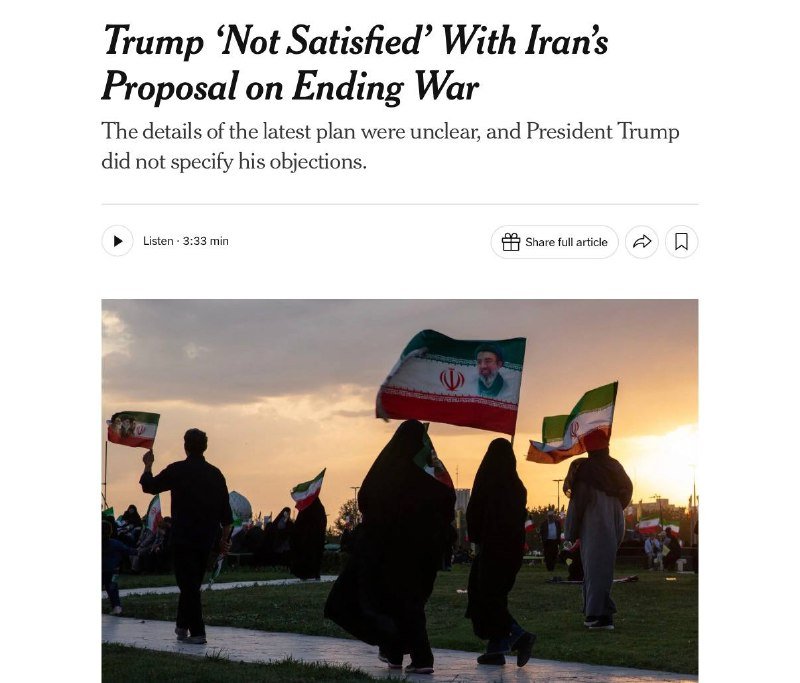 Silhouetted figures, including women in dark robes, walk outdoors at sunset while waving Iranian flags bearing a portrait of a man.