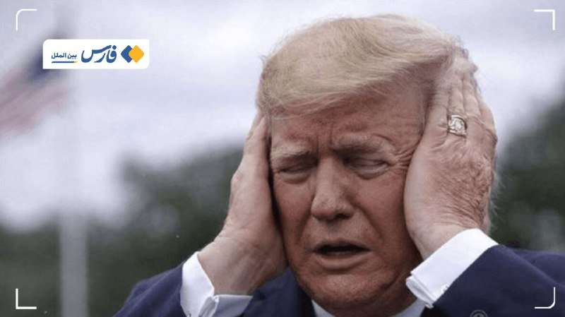 A blonde-haired man in a dark suit presses both hands against his ears with a strained expression, framed by a camera-style border with a Persian-language logo.