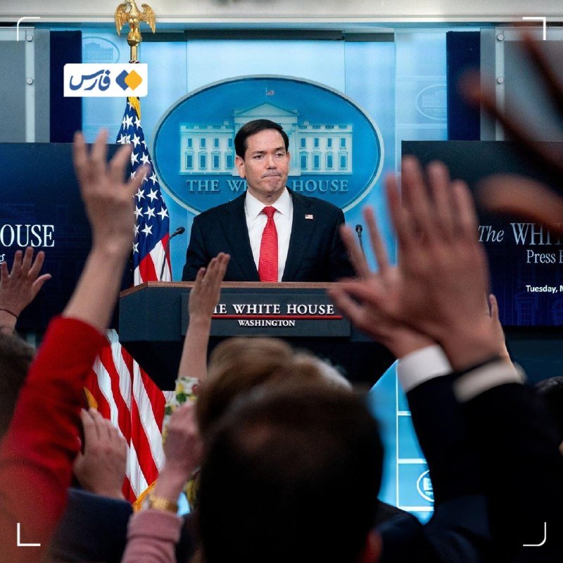 A man in a dark suit and red tie stands at a White House podium while journalists in the foreground raise their hands.