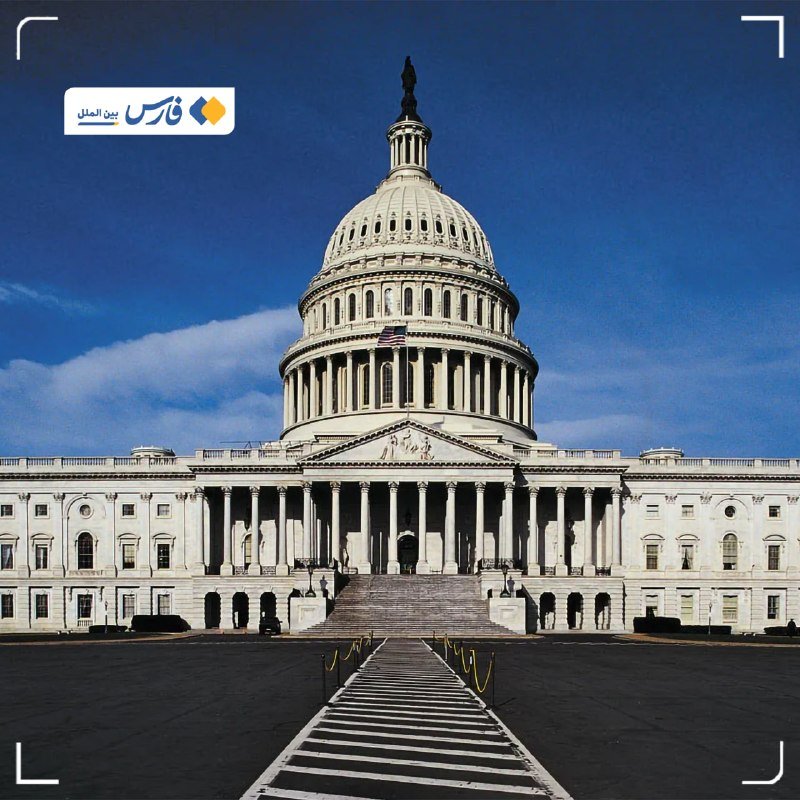 A large white domed government building with columns, an American flag, and a wide staircase stands under a blue sky, with an Arabic logo in the corner.
