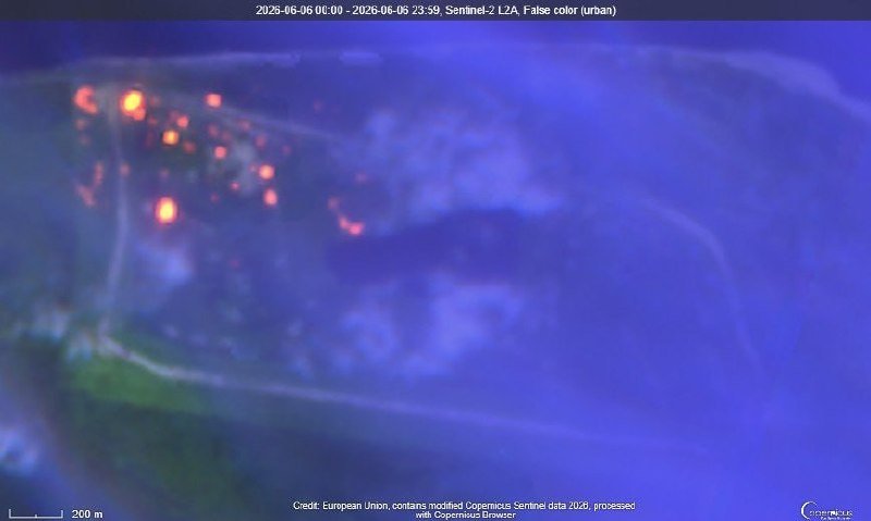 Thermal/infrared satellite imagery shows bright orange hotspots concentrated in the upper-left of a predominantly blue and purple landscape, labeled as Sentinel-2 L2A false-color urban data from Copernicus.