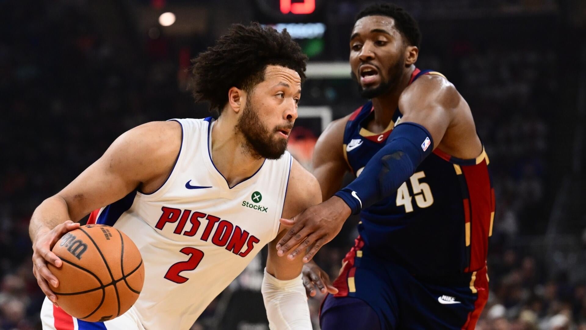 A Pistons player wearing jersey number 2 dribbles a basketball while being defended by a Cavaliers player wearing number 45.