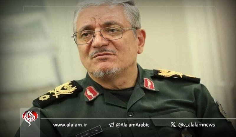A gray-haired man wearing glasses and a green military uniform with insignia looks off-camera.
