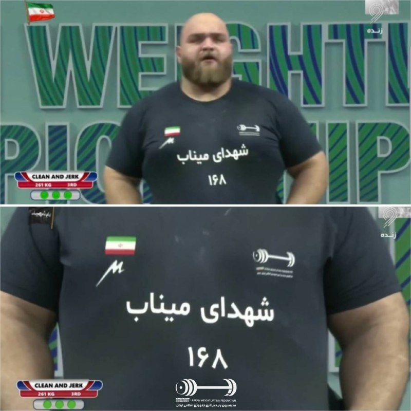 A bearded male weightlifter wearing a black shirt with an Iranian flag and Persian script stands on a competition stage during a clean and jerk attempt.