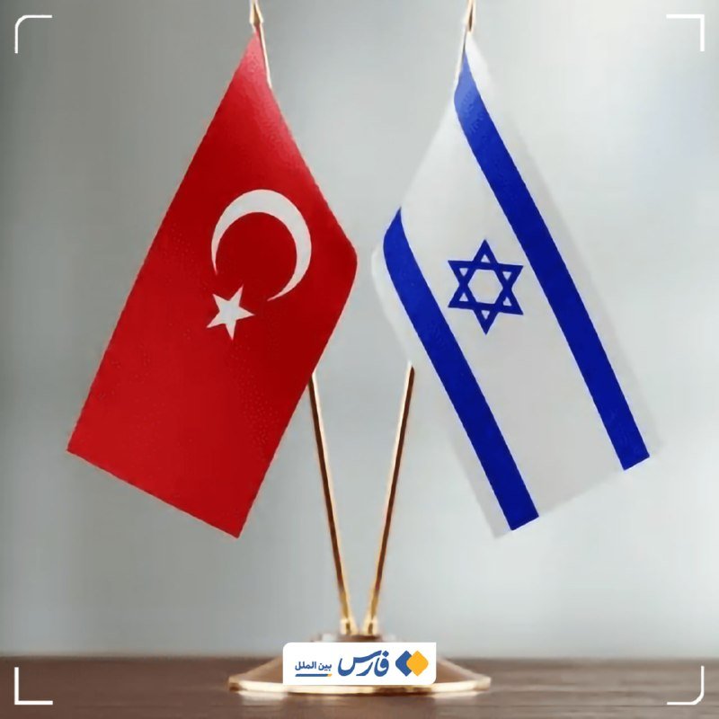 Two small desk flags, one red with a white crescent and star and one white with blue stripes and a Star of David, stand crossed on a gold-colored base.