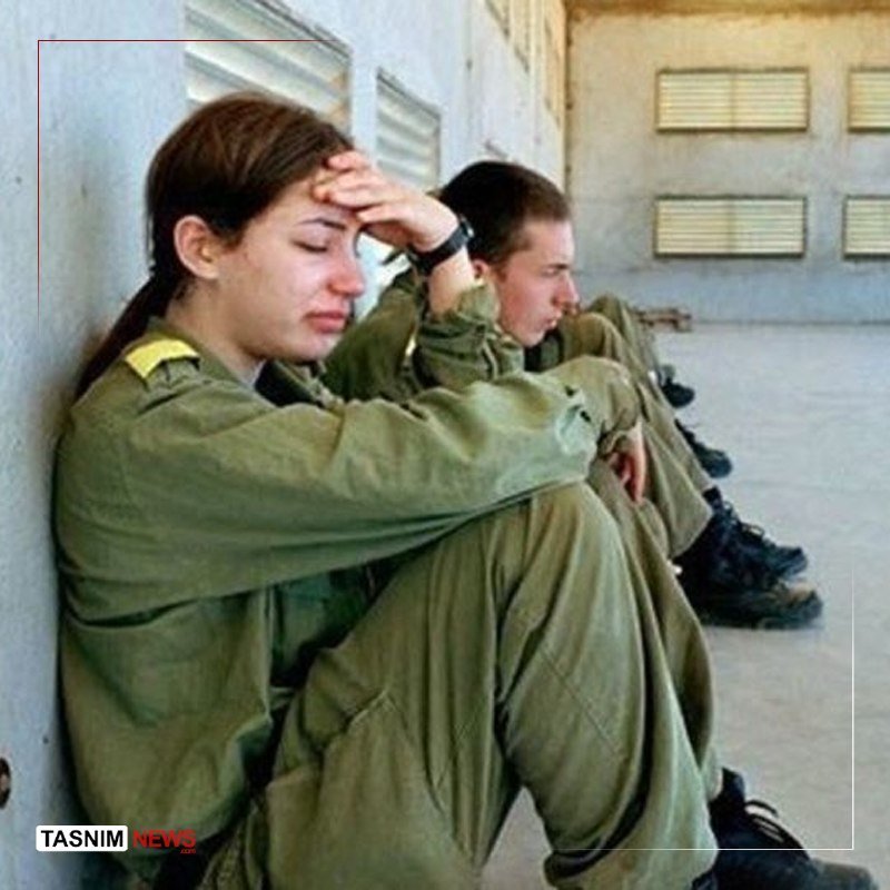 Soldiers in green uniforms sit slumped against a wall, appearing exhausted or distressed, with a Tasnim News watermark visible.