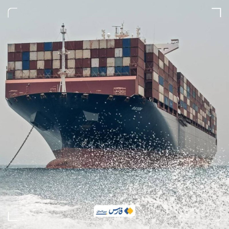 A large container ship loaded with stacked shipping containers sails on open water, with white sea spray in the foreground.
