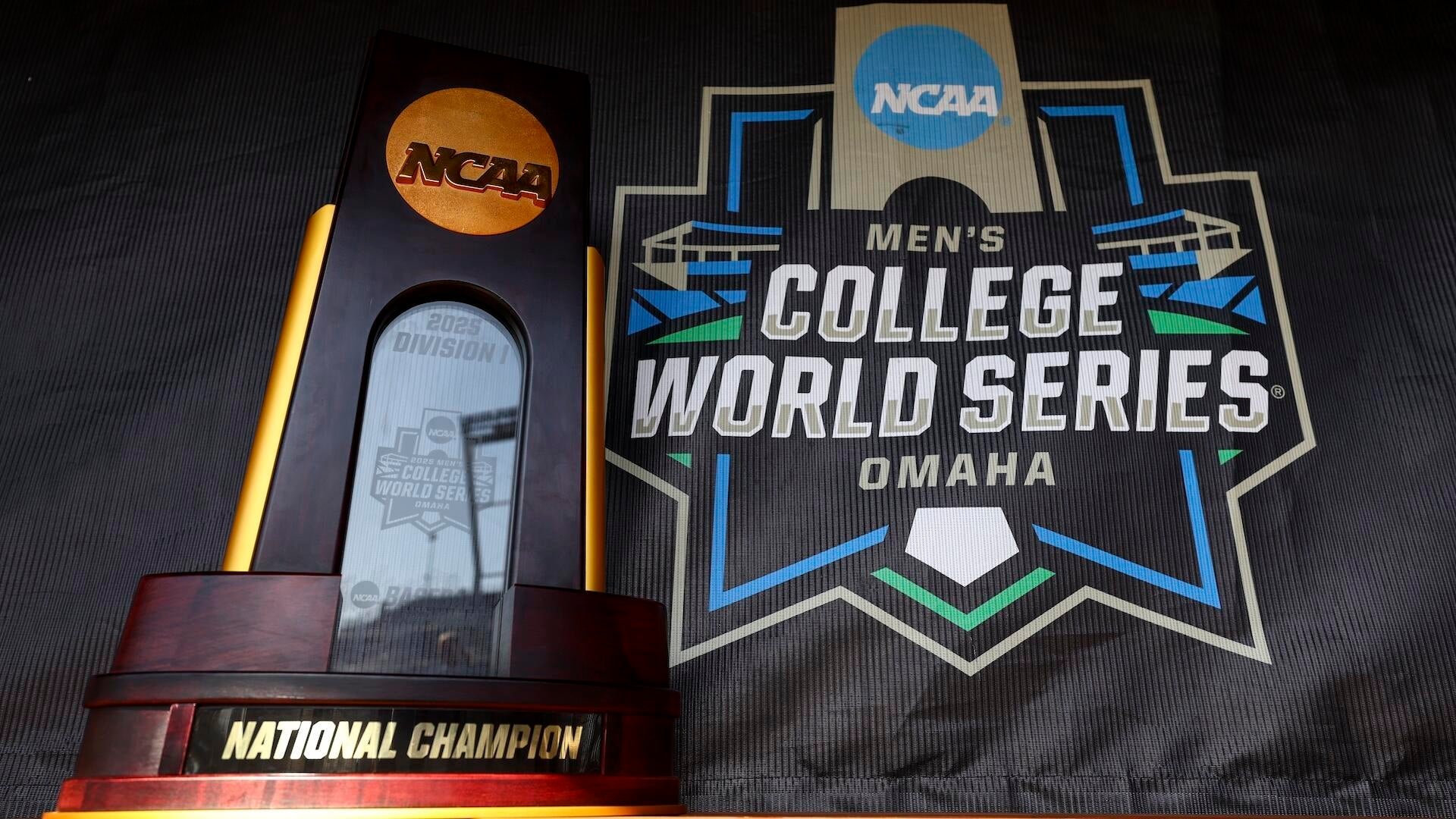 The NCAA Men's College World Series National Championship trophy stands beside the 2025 Omaha event logo displayed on a digital screen.