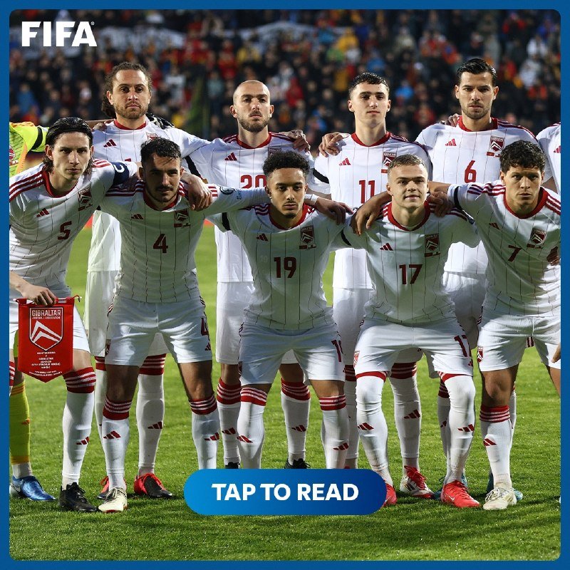 Eleven football players in white and red uniforms pose arm-in-arm for a team photo on a pitch, with a "FIFA" logo at the top and a "TAP TO READ" button below.