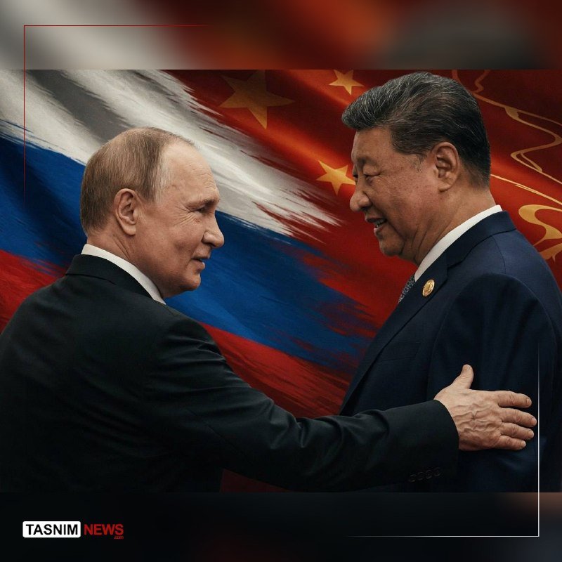 Two men in dark suits shake hands and smile in front of merged Russian and Chinese flags, with a "Tasnim News" logo in the corner.