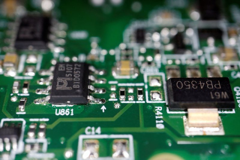 Close-up of a green printed circuit board featuring black microchips labeled "BLD0572" and "FB4350" alongside surface-mount components.