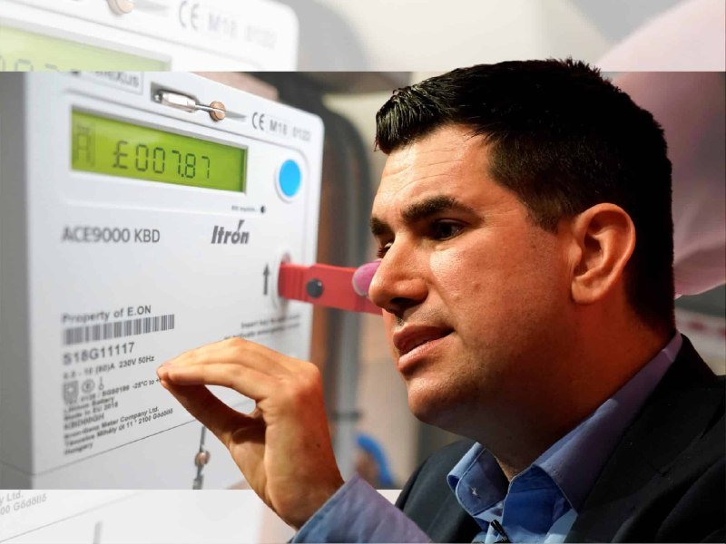 A man in a blue shirt gestures toward an ACE9000 KBD Itron electricity meter displaying "007.87" on its screen.