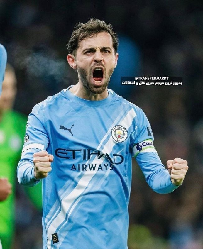 A Manchester City player in a light blue Etihad Airways jersey clenches both fists and shouts in celebration during a match.