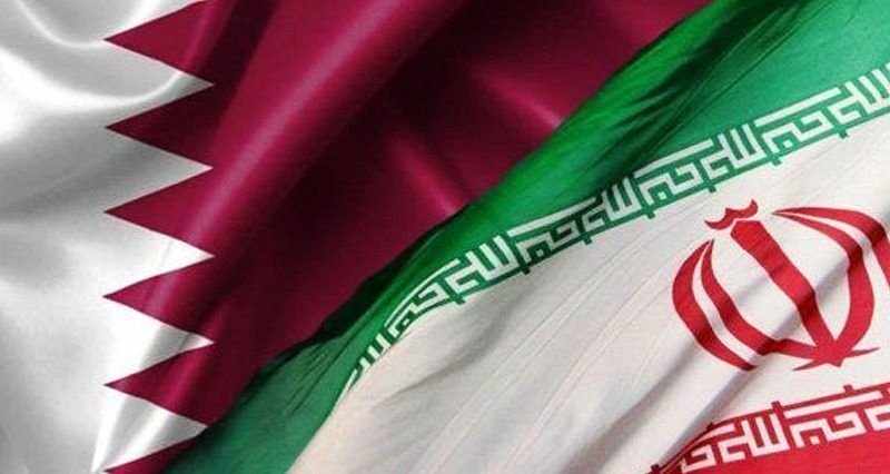 The flags of Qatar and Iran are displayed side by side, overlapping with visible fabric folds and detailed emblems.