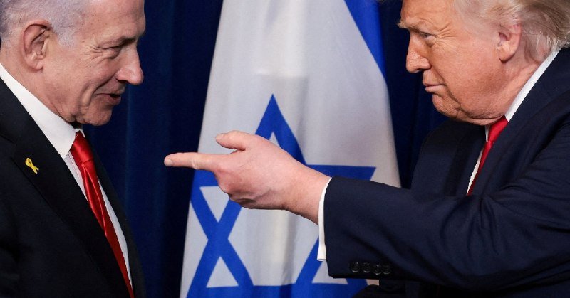 Two men in suits stand face-to-face in front of an Israeli flag, one pointing his finger at the other.