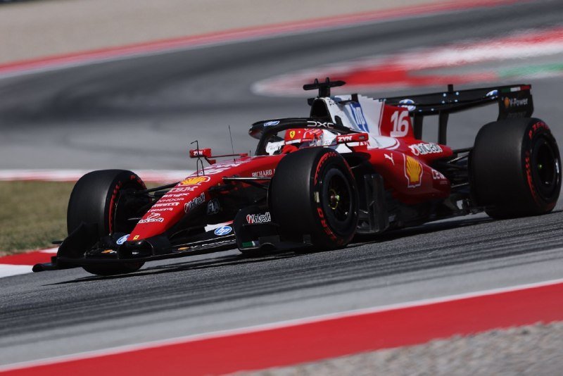 A red Formula 1 race car bearing the number 16 and Shell and Mission Winnow sponsorship logos speeds around a paved track corner marked by red and white curbs.