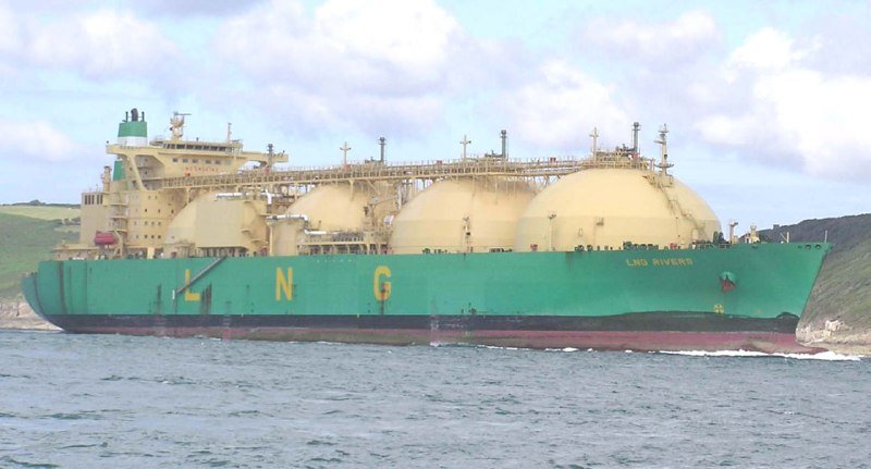A large green and cream LNG tanker named "LNG Rivers" sails through coastal waters with green hillsides in the background under a partly cloudy sky.