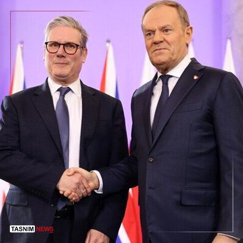 Two men in dark suits shake hands in front of multiple flags and a purple backdrop, with a "Tasnim News" watermark visible.
