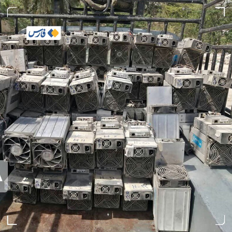 A stack of weathered industrial air conditioning units and fans loaded onto a flatbed truck outdoors.