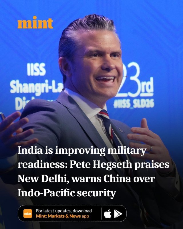 A smiling man in a gray suit and striped tie gestures while speaking at the IISS Shangri-La Dialogue 23rd event, with the "mint" logo visible.