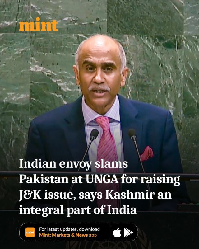 A gray-haired man in a dark suit and pink tie speaks at a podium with two microphones against a green marble backdrop, with overlaid text about an Indian envoy's UNGA remarks.