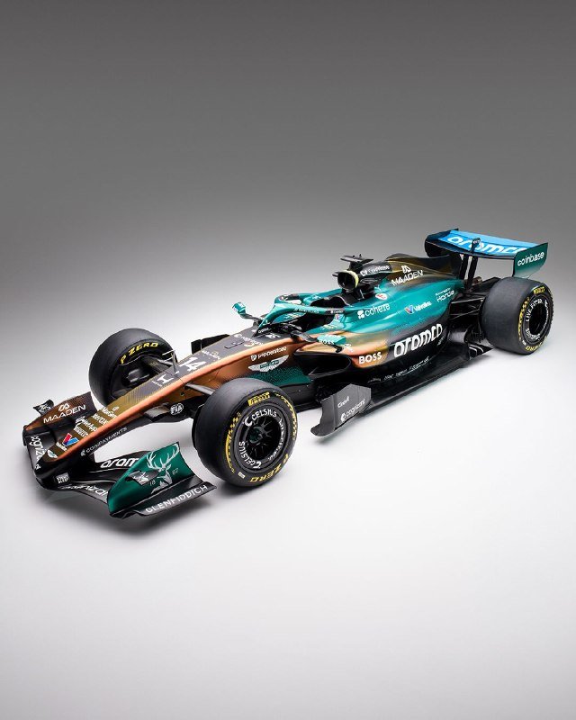 A green and black Formula One race car is displayed against a plain gray background.
