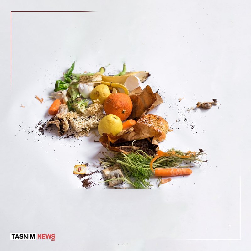 A scattered pile of food waste—including citrus peels, carrot pieces, bread, and herbs—rests on a white surface, with "TASNIM NEWS" labeled in the corner.