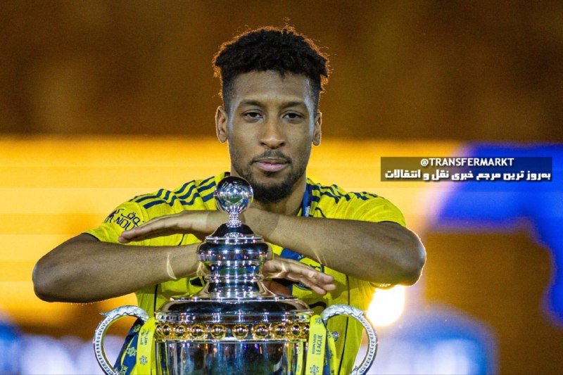 A man in a yellow jersey poses with his arms crossed atop a large silver trophy.