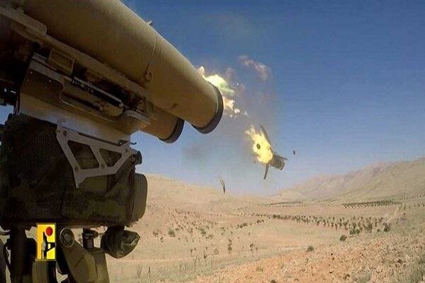 A large tube-launched projectile is captured mid-flight from a military launcher, with smoke and a smaller airborne object visible against an arid, mountainous landscape.
