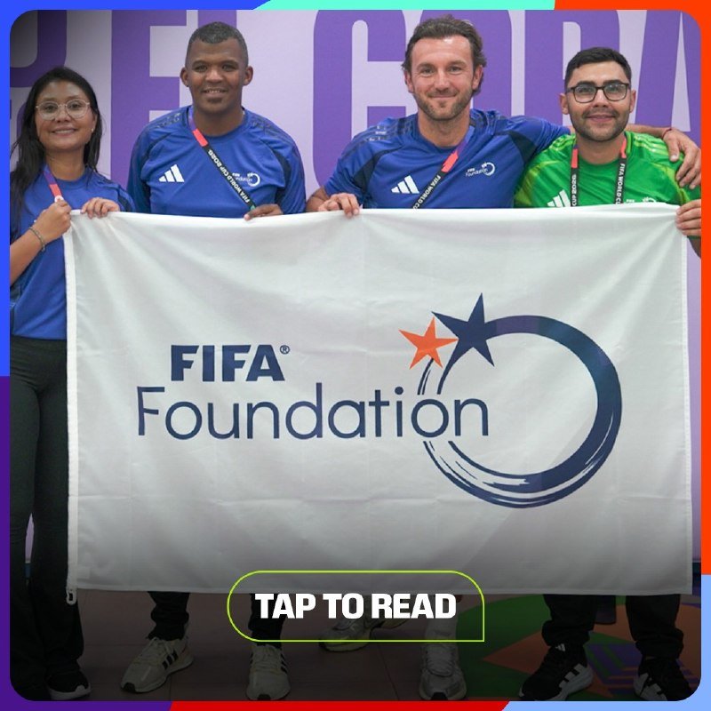 Four smiling people in blue, green, and dark shirts hold up a white FIFA Foundation banner featuring its star logo, with a "TAP TO READ" button displayed below.