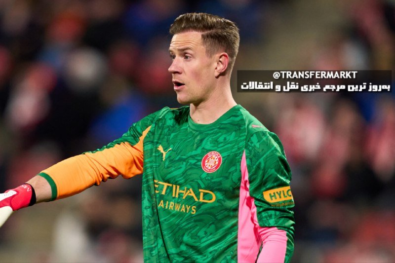 A young male goalkeeper in a green Manchester City "Etihad Airways" jersey stands on a pitch with blurred spectators behind him.