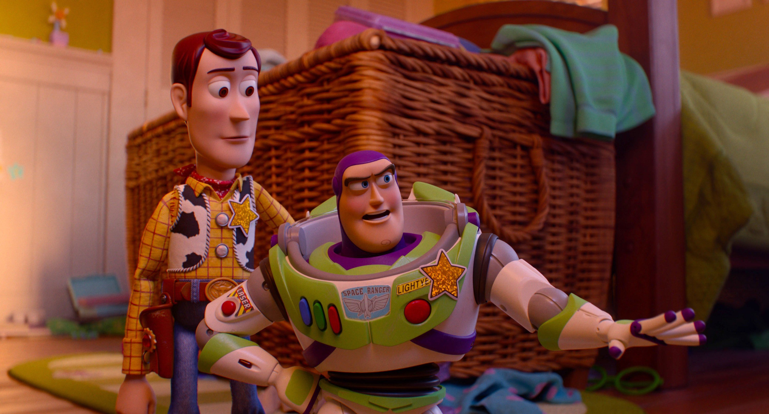 Two toy figures stand in a bedroom: a cowboy doll and a space ranger action figure with a green, white, and purple suit.