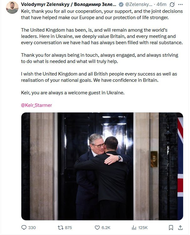 A social media post from Volodymyr Zelenskyy includes a photo of two men in suits embracing in a doorway beside a Union Jack flag.