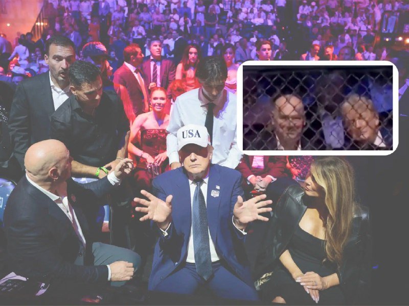 A man in a blue suit and "USA" cap gestures with open hands while seated in a crowded arena, with an inset showing two people behind a chain-link fence.