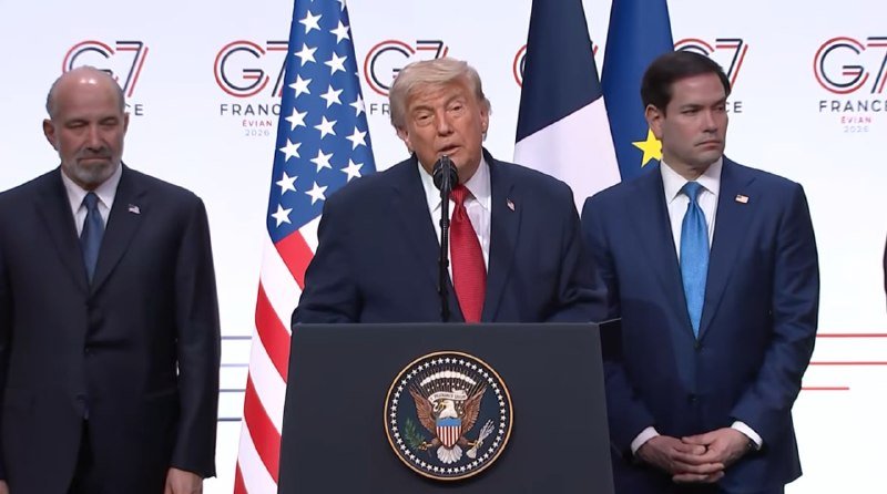 Three men in suits stand at a podium bearing the U.S. presidential seal, with American, French, and EU flags and a "G7 France" backdrop visible behind them.