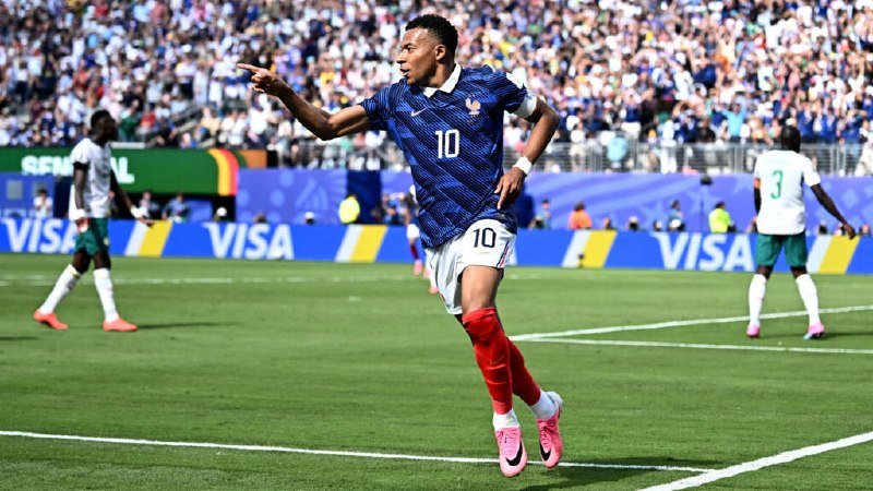 A soccer player wearing a blue jersey with the number 10 celebrates by pointing on a field with "VISA" banners visible.