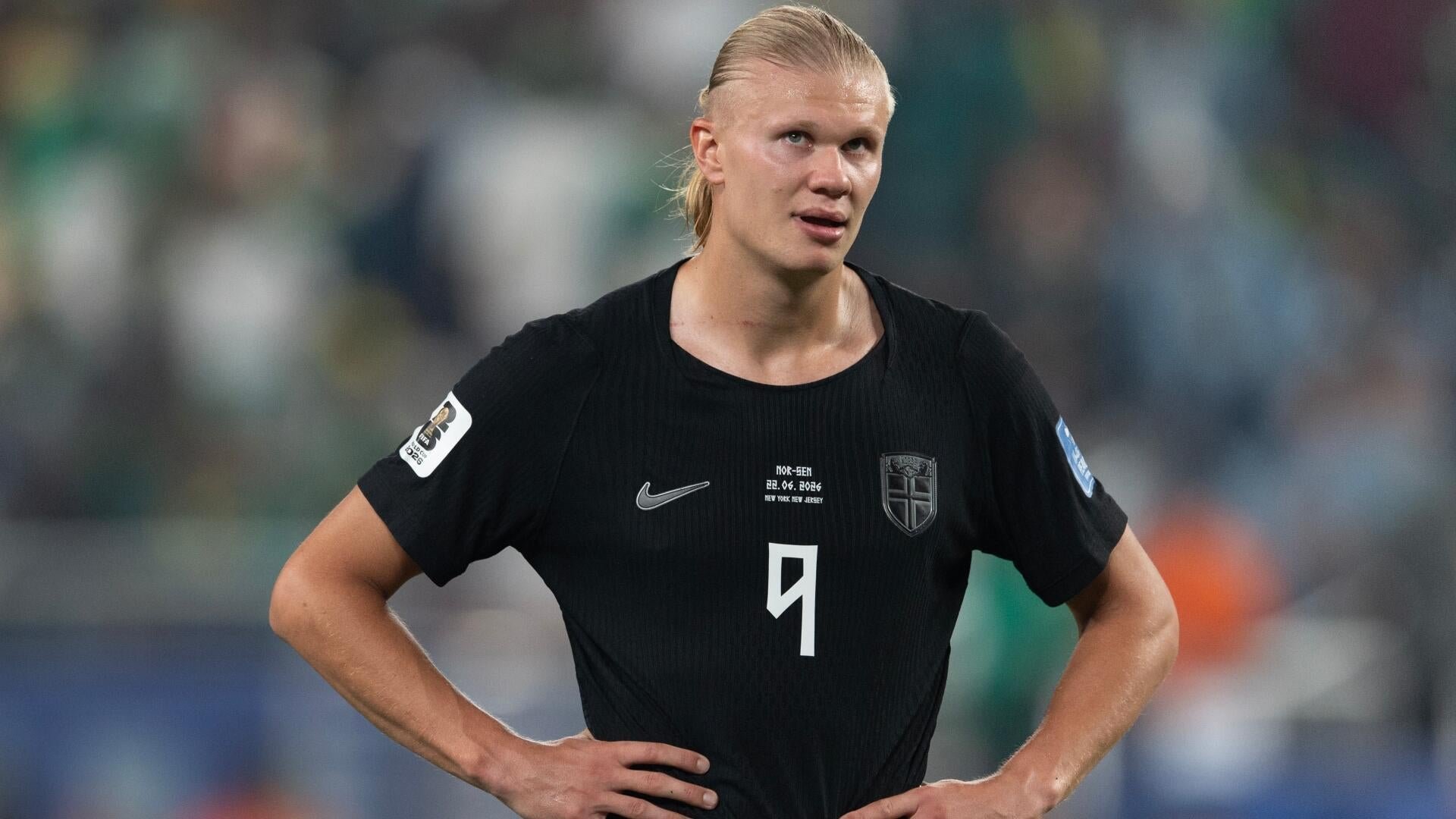 A blonde-haired soccer player wearing a black Norway jersey with the number 9 stands with hands on hips during a match.