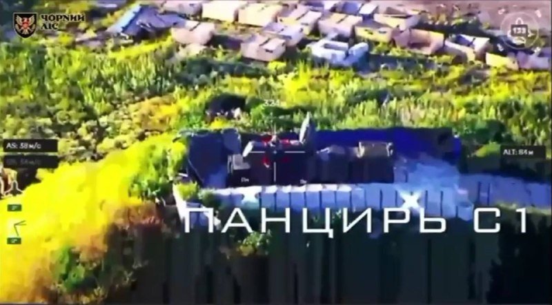 Aerial drone footage shows a fortified compound with sandbags, bearing the text "ПАНЦИРЬ С1" and a "ЧОРНИЙ ЛІС" logo.