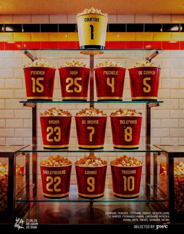 A pyramid of red and gold popcorn buckets labeled with players' names and numbers is displayed on a tiered shelf against a tiled wall.